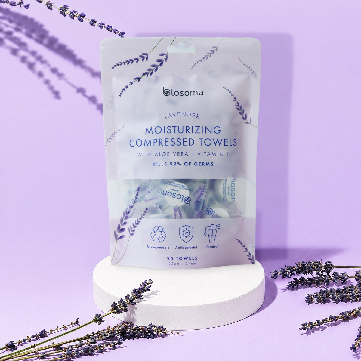 Blosoma antibacterial lavender compressed towels pouch on a pedestal with lavender
